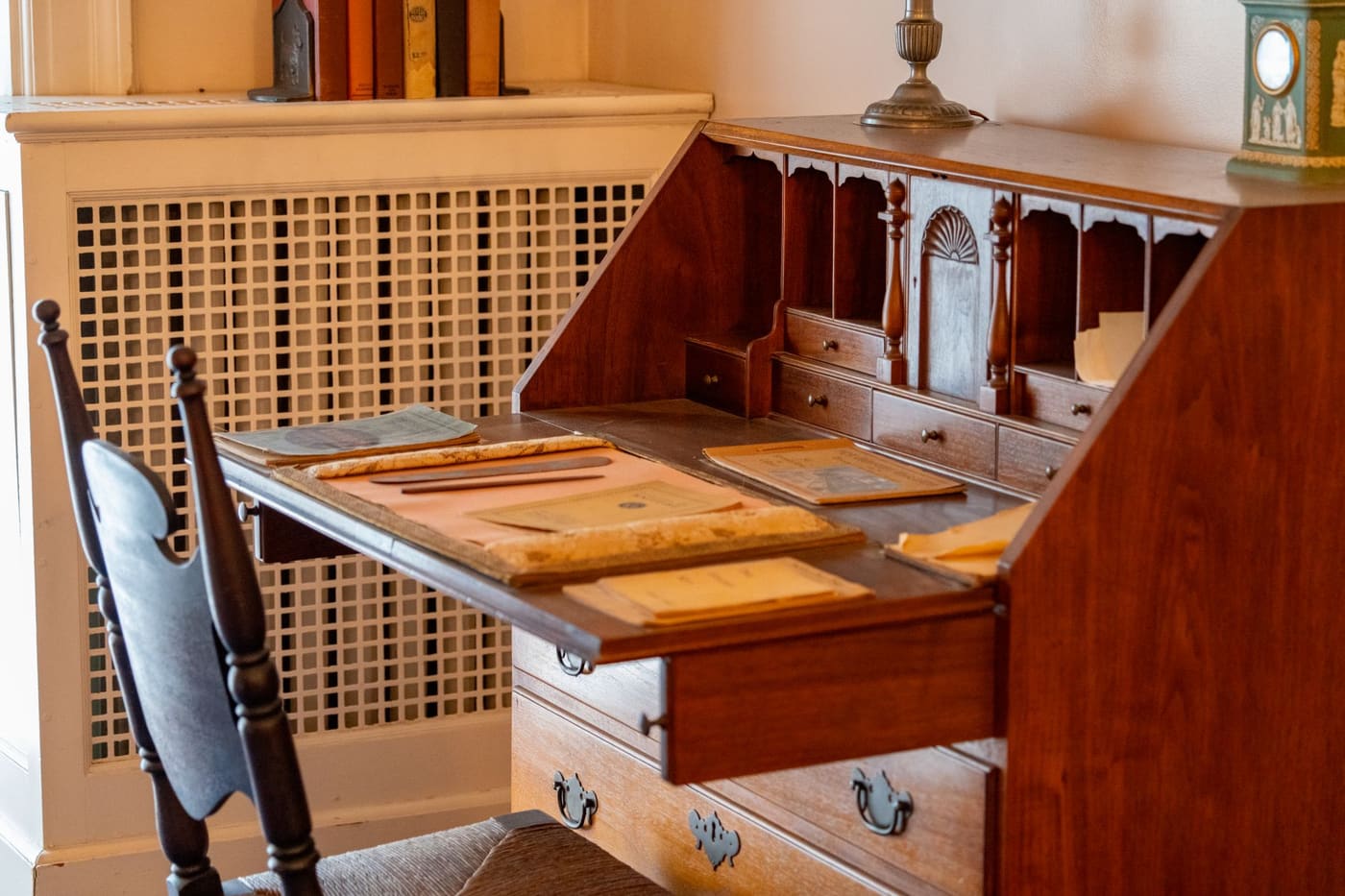 A wooden writing desk with drawers and vintage stationery